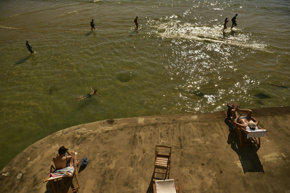 People enjoy a hot summer day at La Concha beach in the basque city of San Sebastian, northern Spain, Friday, Aug. 3, 2018. Hot air from Africa is bringing a heat wave to Europe, prompting health warnings about Sahara Desert dust and exceptionally high temperatures that could peak at 47 degrees Celsius (117 Fahrenheit) in Spain and Portugal. (AP Photo / Alvaro Barrientos)