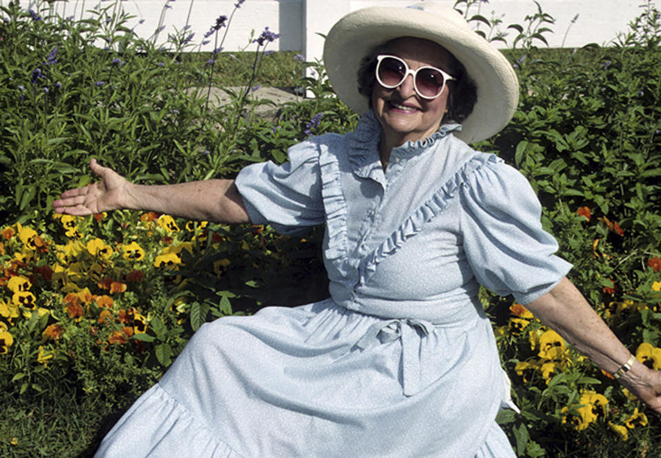 This April 1993 image provided by Lady Bird Johnson Wildflower Center shows Lady Bird Johnson posing among wildflowers at the LBJ Ranch in Stonewall, Texas. (Paul Cox/Lady Bird Johnson Wildflower Center)