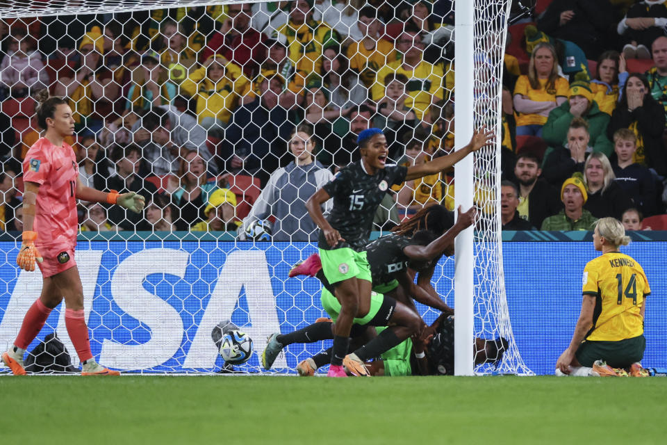 Nigeria players celebrate after teammate Osinachi Ohale, bottom inside the goal, scored their side's second goal during the Women's World Cup Group B soccer match between Australia and Nigeria In Brisbane, Australia, Thursday, July 27, 2023. (AP Photo/Tertius Pickard)