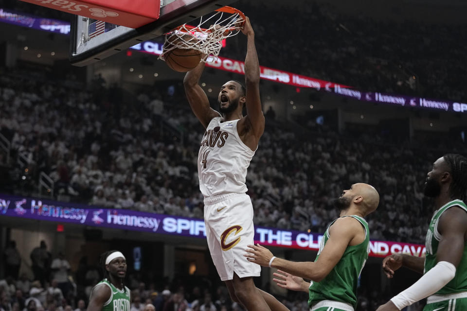 Cleveland Cavaliers forward Evan Mobley (4) dunks in front of Boston Celtics guard Derrick White, second from right, during the first half of Game 3 of an NBA basketball second-round playoff series Saturday, May 11, 2024, in Cleveland. (AP Photo/Sue Ogrocki)