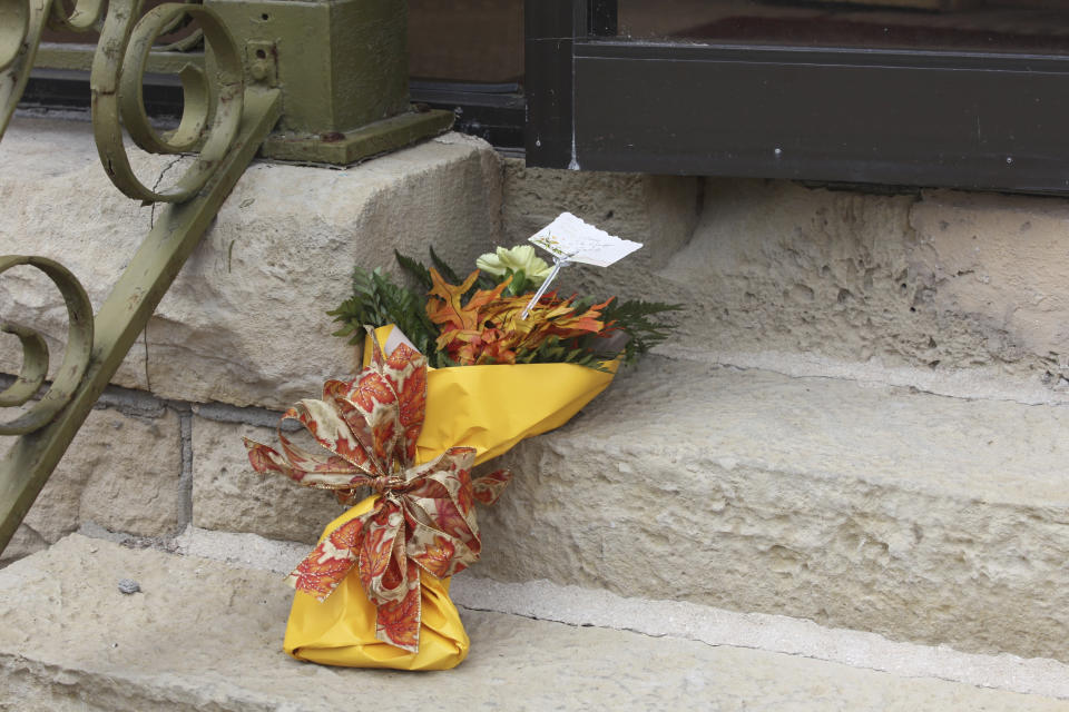A bouquet of flowers sits on the steps of the Marion County Record's offices, honoring the late Joan Meyer, co-owner of the newspaper, Monday, Aug. 14, 2014, in Marion, Kan. The 98-year-old Meyer died Saturday after a police raid on the home she shared with her son, the paper's editor and publisher, and he blames the stress from that raid for her death. (AP Photo/John Hanna)