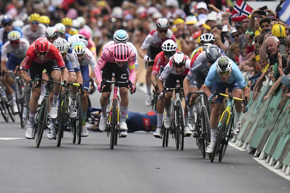 Denmark's Mads Pedersen, rear, crashes as Britain's sprinter Mark Cavendish, far right, sprints to the finish line to win a record 35th Tour de France stage win to break the record of Belgian legend Eddy Merckx in the fifth stage of the Tour de France cycling race over 177.4 kilometers (110.2 miles) with start in Saint-Jean-de-Maurienne and finish in Saint-Vulbas, France, Wednesday, July 3, 2024. (AP Photo/Daniel Cole)