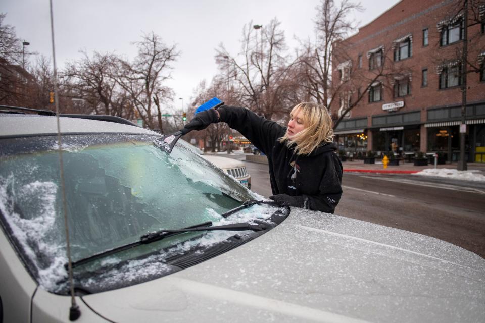 Skyler Potocek, of Denver, scrapes ice off her vehicle on South College Avenue on Wednesday, Jan. 19, 2022.