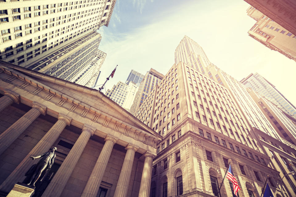 The front of a bank against a city skyline.