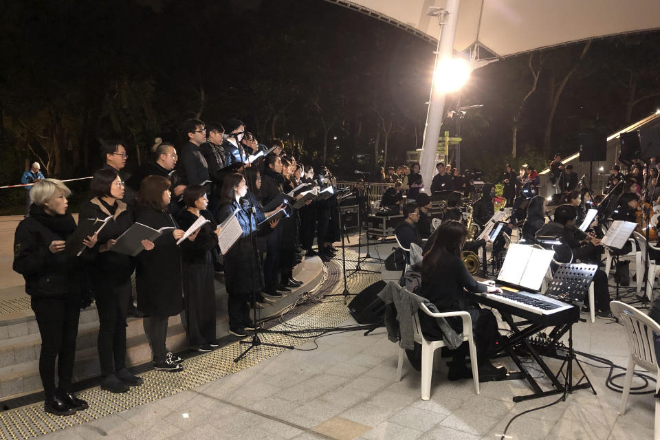 In this Tuesday, Dec. 10, 2019 photo, a theater troupe performs Les Miserables in at an outdoor event space in Hong Kong. A Hong Kong theater troupe is making audiences weep by touring a stirring production of 'Les Miserables.' Based on Victor Hugo's tale of rebellion in 19th-century France, the rousing music and lyrics of struggle and resistance struck chords with audience members emotionally and physically drained after six months of protests that have convulsed the city. (AP Photo/John Leicester)