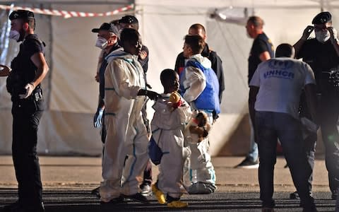 Migrants disembark from the Italian Coast Guard vessel "Diciotti" at the port of Pozzallo, Sicily on June 19, 2018, following a rescue operation at sea - Credit: Giovanni Isolino/AFP