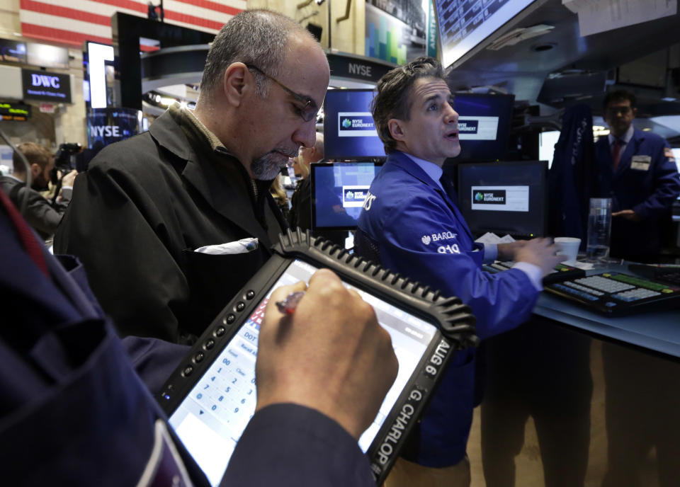 Specialist Anthony Rinaldi, right, works with traders at his post on the floor of the New York Stock Exchange Wednesday, Jan. 29, 2014. Stocks are lower in early trading as weak earnings from several U.S. companies dented investors' confidence. Worries about emerging markets were also coming back after relief faded over an effort by Turkey to shore up its struggling currency. (AP Photo/Richard Drew)