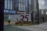 A worker waters flowers decoration to celebrate the 25th anniversary of Hong Kong handover to China, in Hong Kong, Monday, June 27, 2022. As the former British colony marks the 25th anniversary of its return to China, reeling from pandemic curbs that devastated business and a crackdown on its pro-democracy movement, Hong Kong leaders say it is time to transform again and become a tech center that relies more on ties with nearby Chinese factory cities than on global trade. (AP Photo/Kin Cheung)