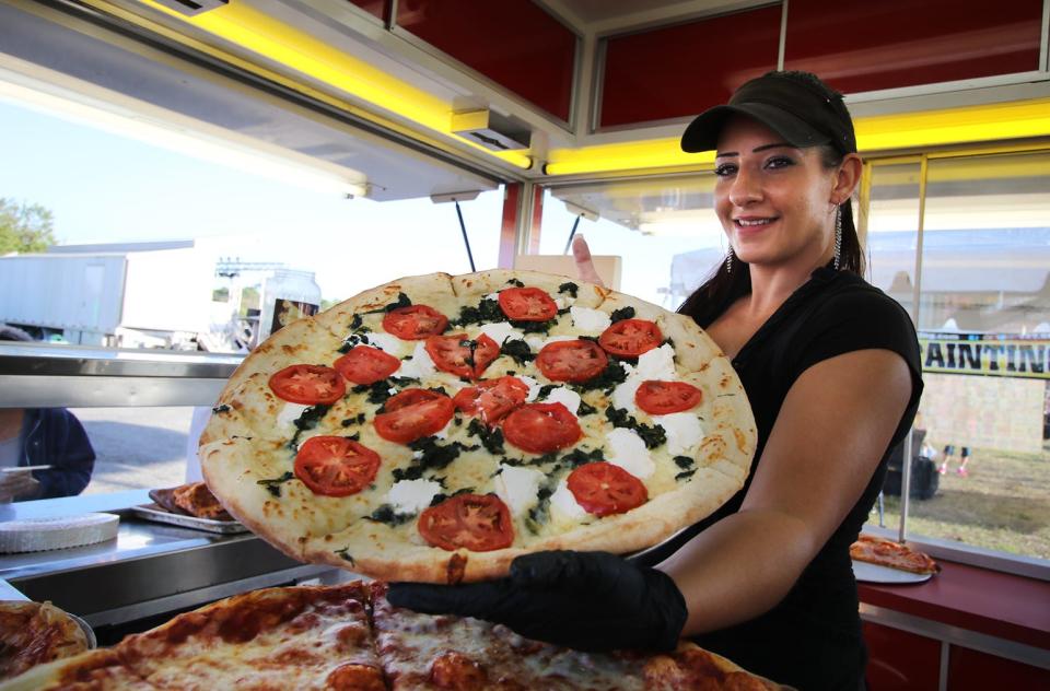Kristen Ricketts serves up pizza at the Venice Italian Feast & Carnival at the Venice Airport fairgrounds.