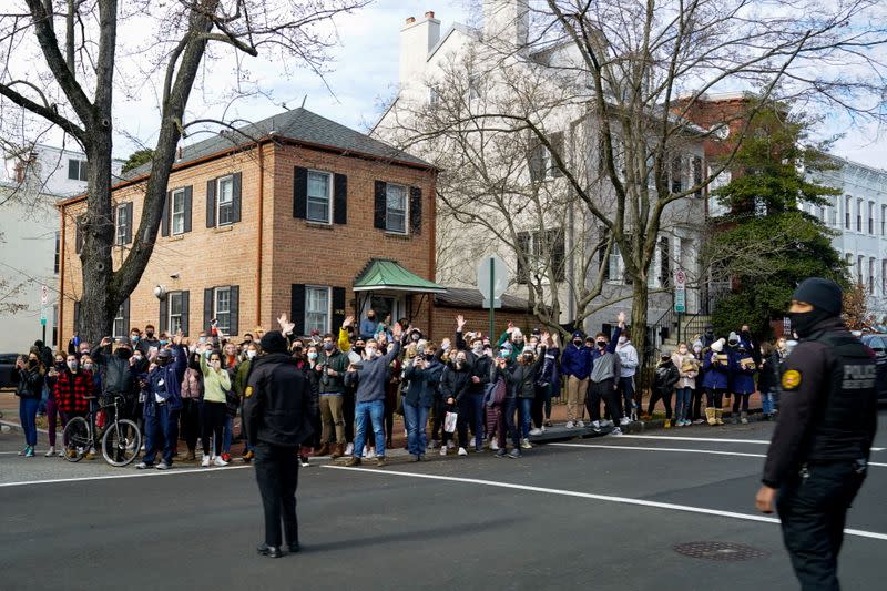 Bystanders react as U.S. President Joe Biden's motorcade departs Holy Trinity Catholic Church in Washington
