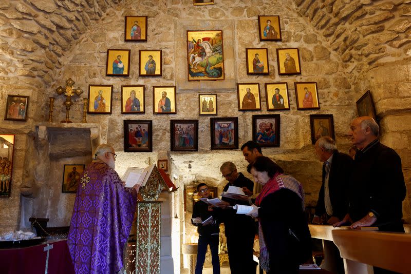 Christian worshipers pray inside St. George Church, also known as the Church of the Ten Lepers, in Burqin