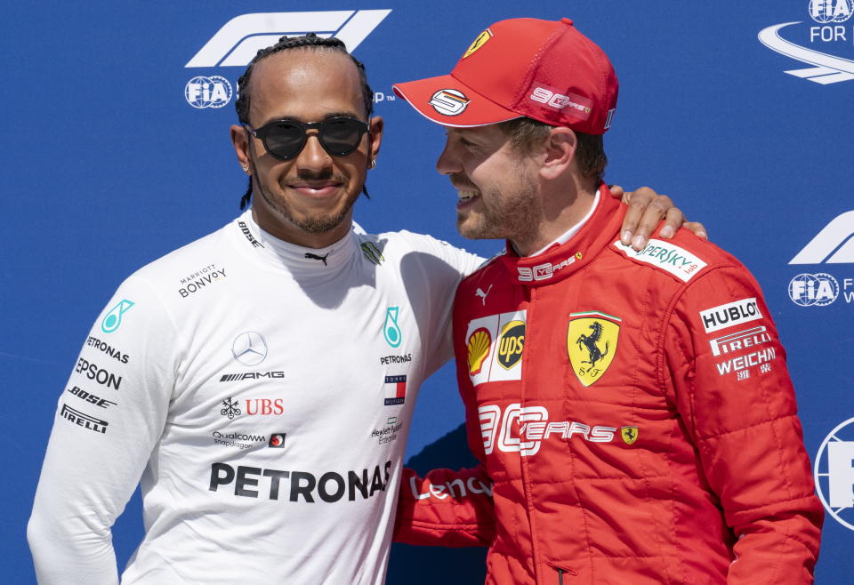 Mercedes driver Lewis Hamilton, left, of Great Britain congratulates Ferrari driver Sebastian Vettel of Germany for taking the pole position during qualifying for the Formula One Canadian Grand Prix auto race in Montreal, Saturday, June 8, 2019. (Paul Chiasson/The Canadian Press via AP)