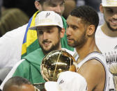 San Antonio Spurs' Tim Duncan (R) holds the Larry O'Brien trophy as he congratulates Marco Belinelli of Italy after the Spurs defeated the Miami Heat in Game 5 of their NBA Finals basketball series in San Antonio, Texas, June 15, 2014. REUTERS/Mike Stone (UNITED STATES - Tags: SPORT BASKETBALL)