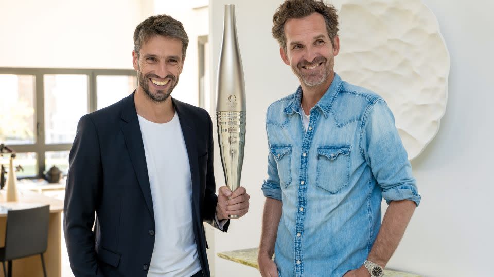 Chair of the Paris 2024 organizing committee Tony Estanguet (left) and designer Mathieu Lehanneur (right) pose with the latter's Olympic and Paralympic Torch. - Paris 2024/International Olympic Committee