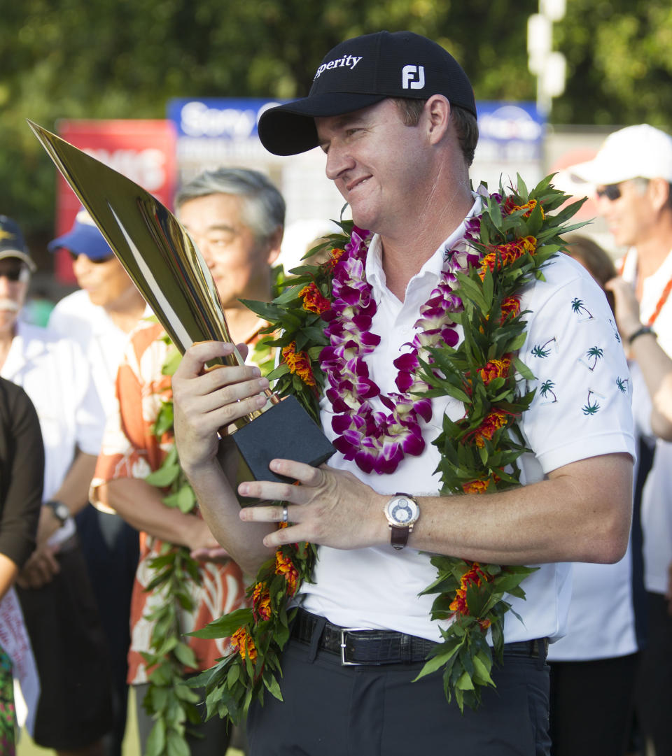 Jimmy Walker looks at the championship trophy after winning the Sony Open golf tournament at Waialae Country Club, Sunday, Jan. 12, 2014, in Honolulu. (AP Photo/Eugene Tanner)