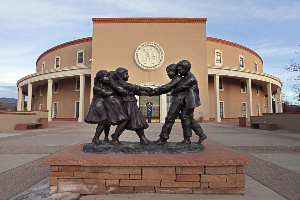 FILE - The sculpture "Tug 'O War" sculpture by artist Glenna Goodacre sits at the entrance to the New Mexico State capitol building in Santa Fe, N.M., on Jan. 13, 2021. A rural New Mexico county’s initial refusal to certify its primary election results sent ripples across the country last week, a symbol of how even the most elemental functions of democracy have become politicized pressure points amid the swirl of lies stemming from the 2020 presidential outcome. (AP Photo/Cedar Attanasio, File)