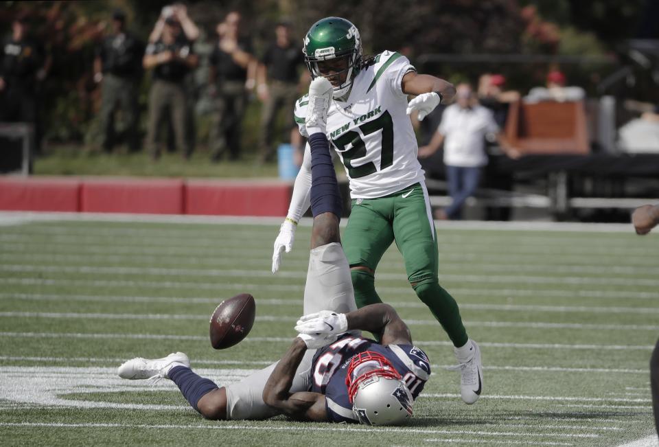 New England Patriots wide receiver Josh Gordon hits the turf while trying to catch a pass in front of New York Jets cornerback Darryl Roberts (27) during the first half of an NFL football game, Sunday, Sept. 22, 2019, in Foxborough, Mass. (AP Photo/Elise Amendola)