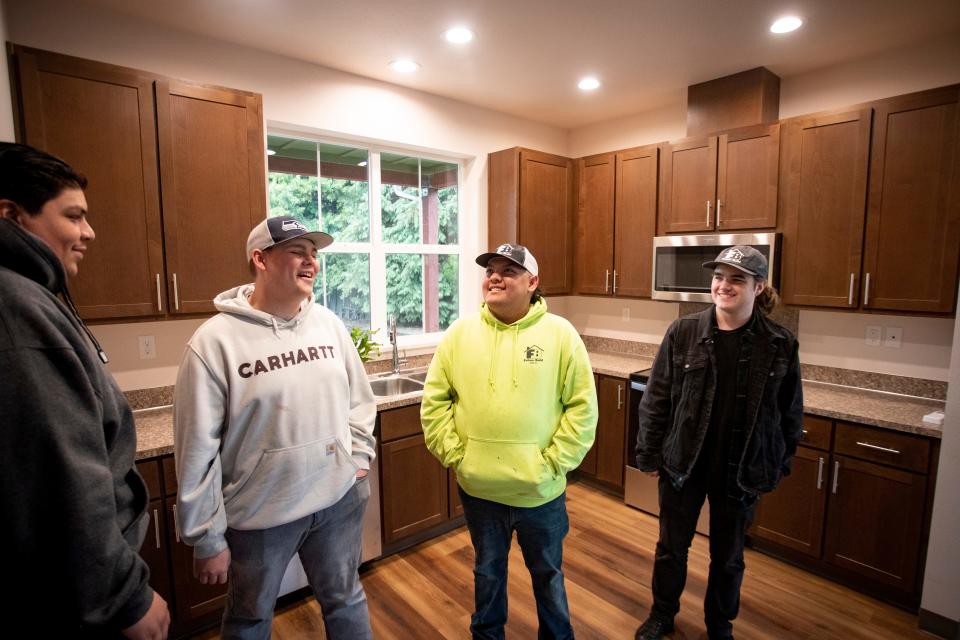 Joel Delgadillo, left, Brayden O’Keeffe-Gotchall, Francisco Collazo and Evan Walklin walk through the kitchen of a home they helped construct with Eugene School District 4J’s Future Build program.