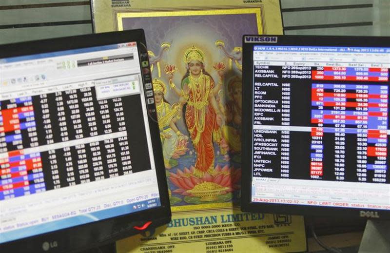 An image of Lakshmi, the Hindu goddess of wealth and prosperity, is placed between monitors displaying share price index at a share trading market in Chandigarh August 29, 2013. REUTERS/Ajay Verma