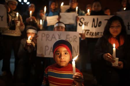 A boy holding a candle attends a candle light vigil in Kathmandu, December 17, 2014, for the students killed at the military-run Army Public School in Peshawar. REUTERS/Navesh Chitrakar