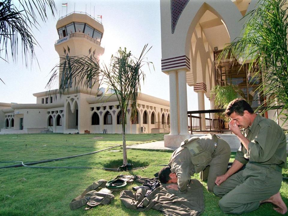 Palestinian policemen pray in front of Gaza International Airport on October 27, 1998.