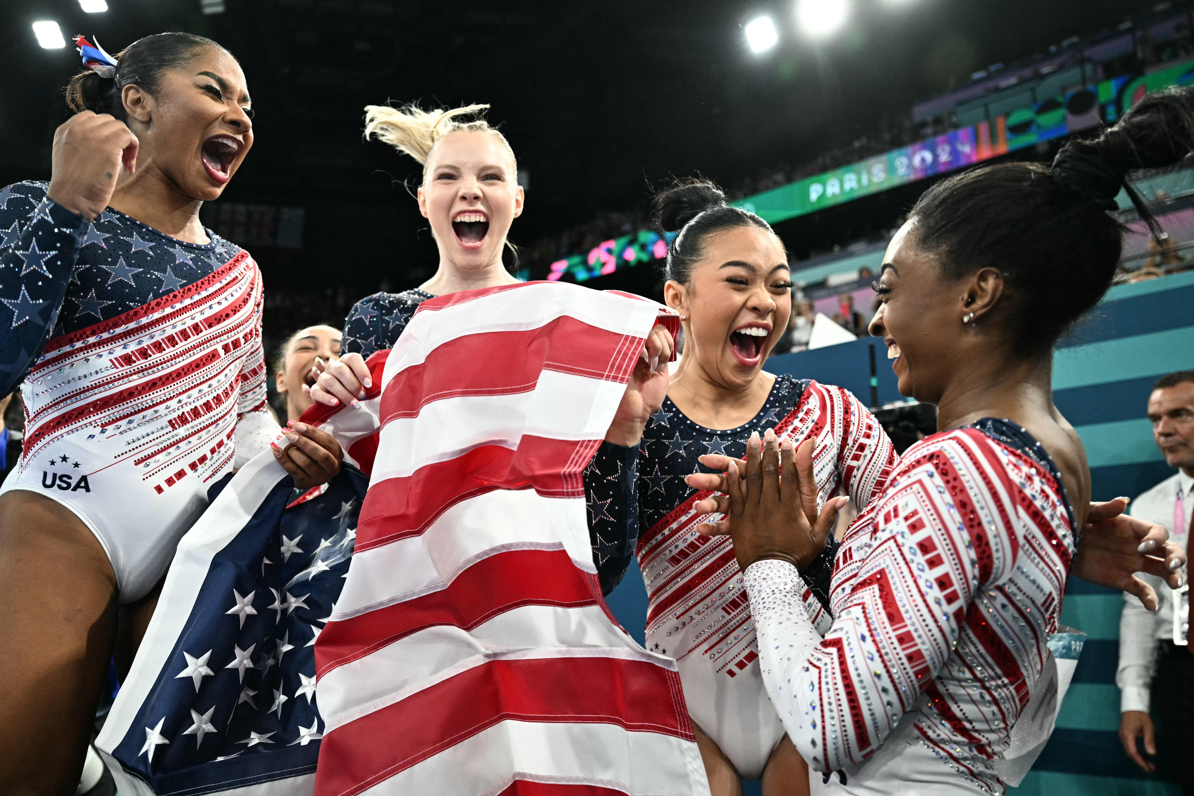 US' Simone Biles (R) and teammates celebrate after team USA won the artistic gymnastics women's team final during the Paris 2024 Olympic Games at the Bercy Arena in Paris, on July 30, 2024. (Photo by Lionel BONAVENTURE / AFP)