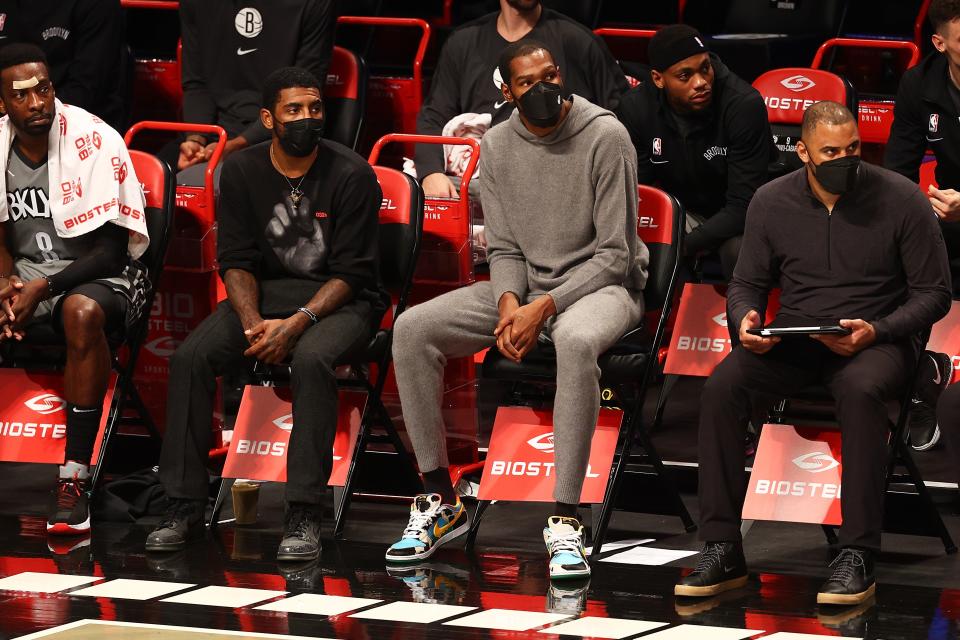 Kyrie Irving and Kevin Durant of the Brooklyn Nets watch a game against the Memphis Grizzlies in Brooklyn, December 28, 2020.