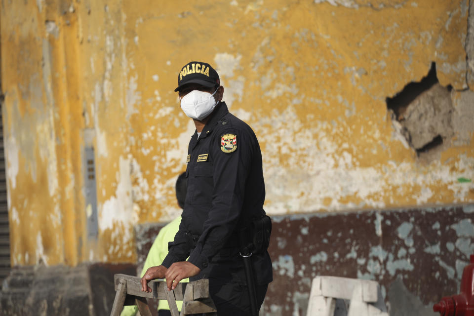 A police officer mans a barricade outside Congress where Francisco Sagasti is to be sworn-in as the new, interim president in Lima, Peru, Tuesday, Nov. 17, 2020. Sagasti's appointment marks a tumultuous week in which thousands took to the streets outraged by Congress' decision to oust popular ex-President Martín Vizcarra. (AP Photo/Rodrigo Abd)