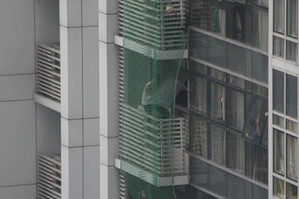 The man later appeared to voluntarily re-enter the seventh floor unit. (PHOTO: Dhany Osman / Yahoo News Singapore)