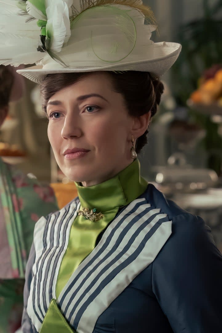 Carrie Coon holding a tea cup, in period attire, in a scene from 