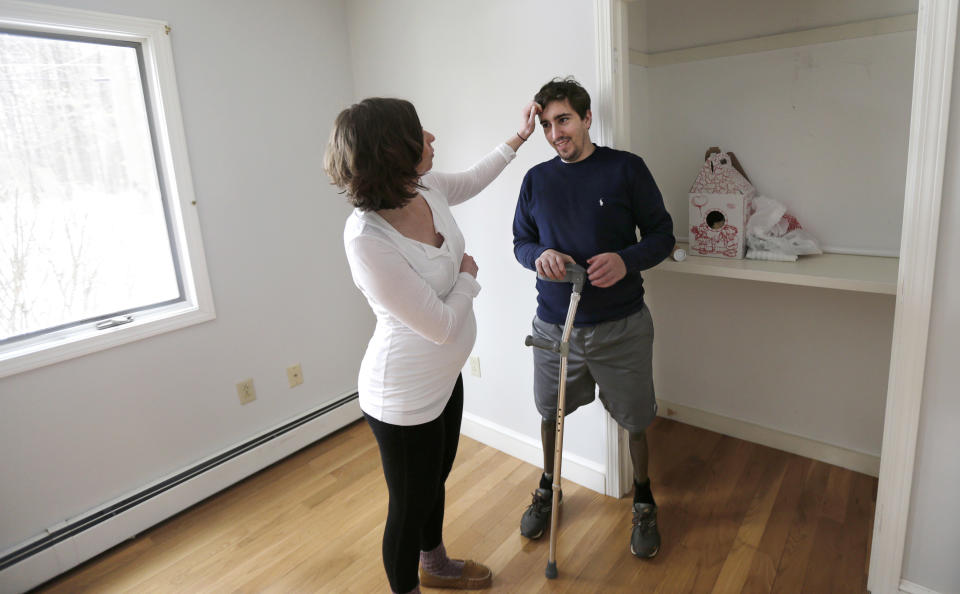 ADVANCE FOR WEEKEND USE APRIL 4-5 -- In this March 14, 2014 photo, Jeff Bauman smiles as his fiancee Erin Hurley touches his hair in the soon-to-be nursery of their Carlisle, Mass., home. The couple are expecting their first child in July. Bauman, who lost both his legs above the knee in the Boston Marathon bombing, is learning to adjust to his prosthetics. It takes more energy to walk with prosthetics, which means he gets tired more easily. (AP Photo/Charles Krupa)