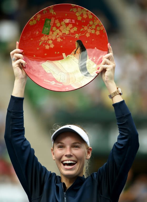 Caroline Wozniacki of Denmark holds the winner's plate during the awards ceremony for the the Pan Pacific Open in Tokyo on September 25, 2016