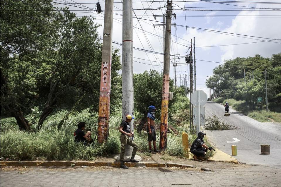 Armed students stand guard near the National Autonomous University of Managua on June 30.