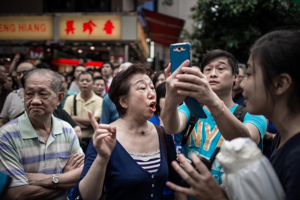 An anti-protester (C) argues with a student (R), part of a group protecting a barricade in an occupied area of Hong Kong on October 3, 2014. (PHILIPPE LOPEZ/AFP/Getty Images)