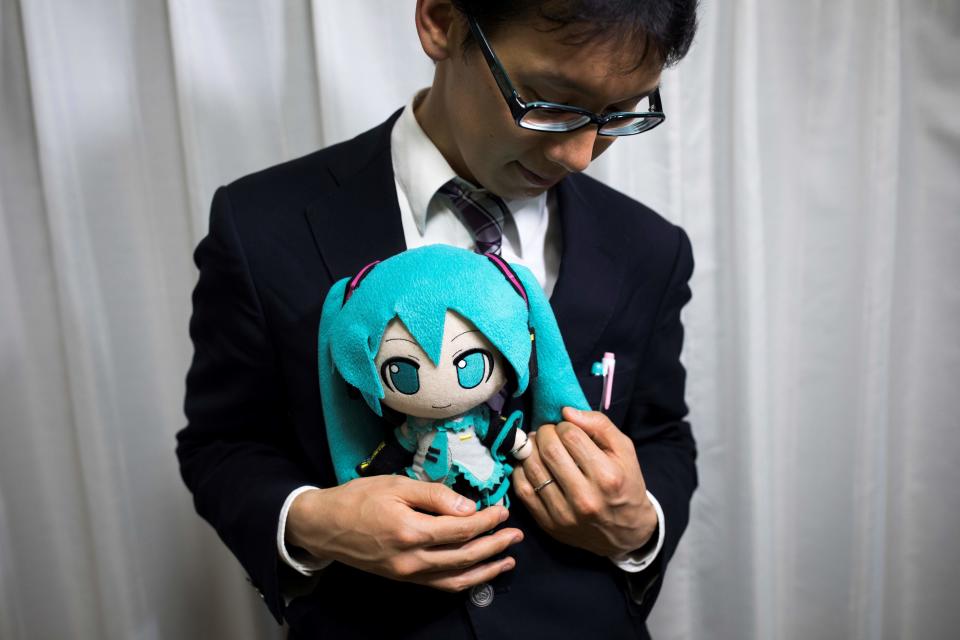 Groom Akihiko Kondo, 35, with a Hatsune Miku stuffed doll at the wedding. (Photo: BEHROUZ MEHRI via Getty Images)