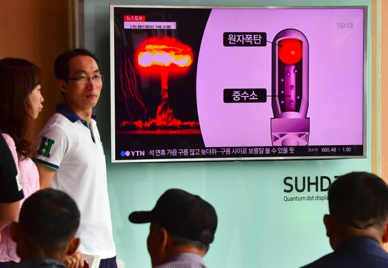 People watch a television news report on North Korea's latest nuclear test, at a railway station in Seoul, on September 9, 2016