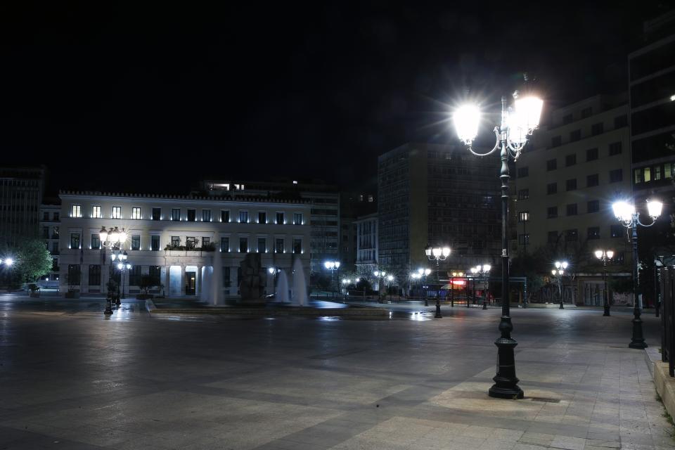 In this Thursday, April 2, 2020 photo, a view of the empty Kotzia square, with the Athens City Hall in the background in central Athens during the lockdown. Deserted squares, padlocked parks, empty avenues where cars were once jammed bumper-to-bumper in heavy traffic. The Greek capital, like so many cities across the world, has seen its streets empty as part of a lockdown designed to stem the spread of the new coronavirus. (AP Photo/Thanassis Stavrakis)