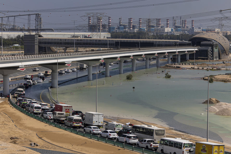 Vehicles drive through standing floodwater caused by heavy rain on an onramp to Sheikh Zayed Road highway in Dubai, United Arab Emirates, Thursday, April 18, 2024. The United Arab Emirates attempted to dry out Thursday from the heaviest rain the desert nation has ever recorded, a deluge that flooded out Dubai International Airport and disrupted flights through the world's busiest airfield for international travel. (AP Photo/Christopher Pike)