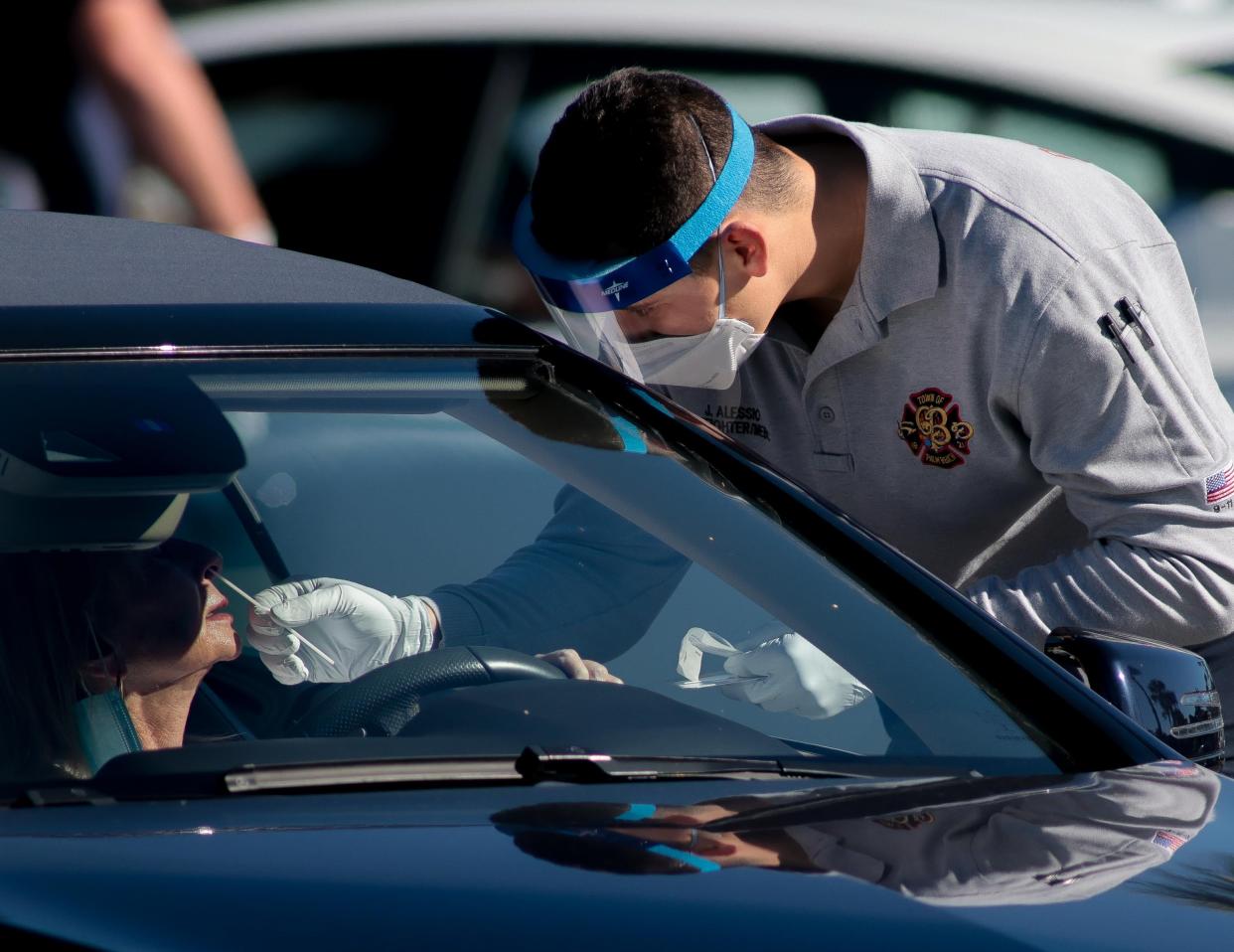 A Palm Beach Fire Rescue worker administers a COVID-19 Rapid Antigen Test to a resident at Phipps Ocean Park on Jan. 6.