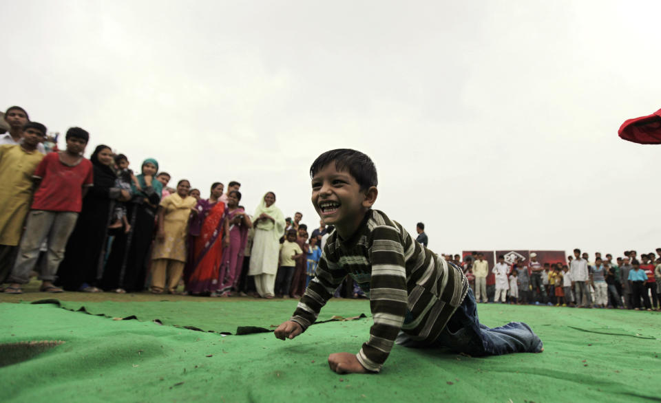 An Indian boy suffering with birth defects competes in a "crab-walk" race during a "Special Olympics" held by the survivors of the deadly 1984 Bhopal gas leak in an effort to shame Olympic sponsor Dow Chemical Co. on the eve of the London Games in Bhopal, India, Thursday, July 26, 2012. Survivors say Dow owes them compensation for the world's worst industrial disaster and have campaigned to have the chemical giant dropped as a sponsor of the Olympics. Dow says it has no liability because it bought the company responsible for the plant more than a decade after the cases had been settled. (AP Photo/Altaf Qadri)
