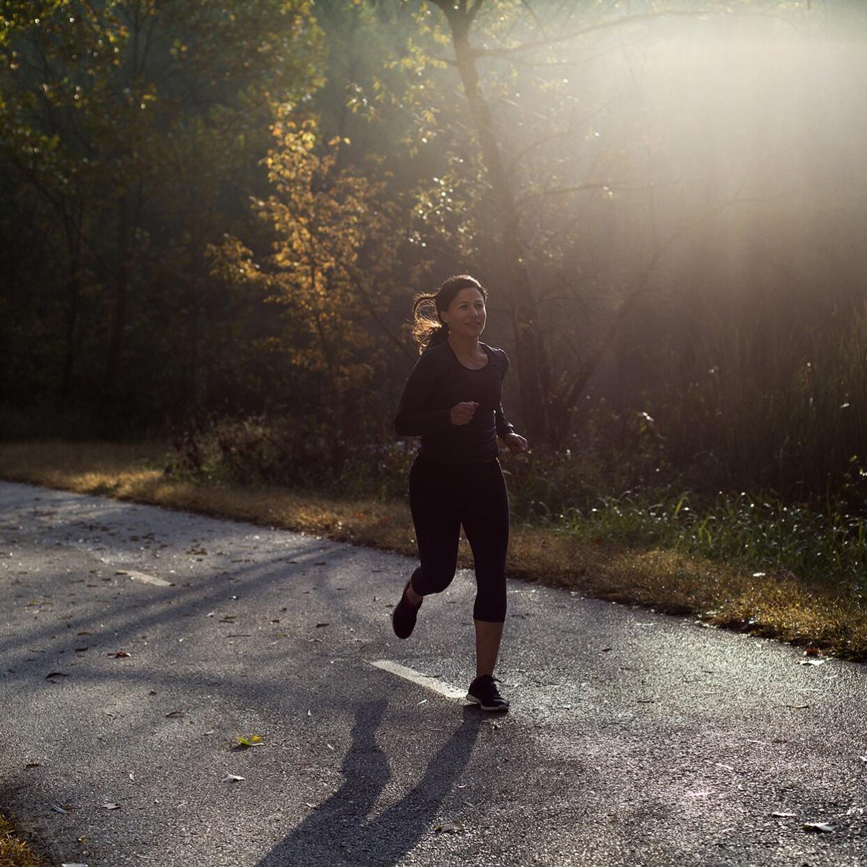 Woman running on a road during the morning