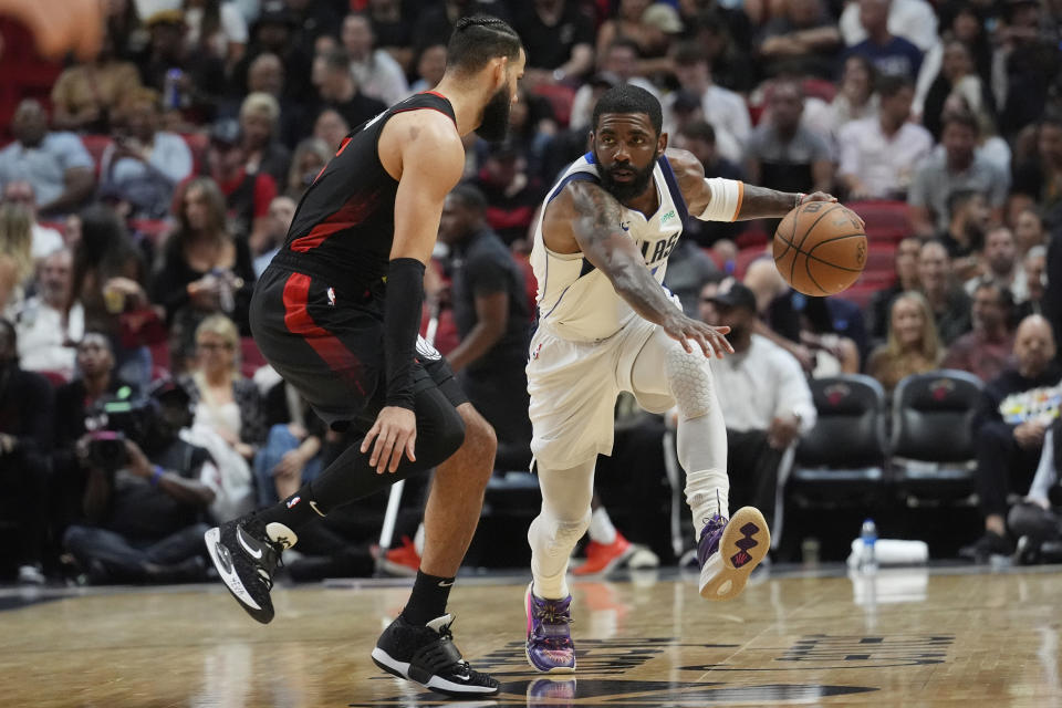 Dallas Mavericks guard Kyrie Irving (11) dribbles around Miami Heat forward Caleb Martin (16) during the first half of an NBA basketball game, Wednesday, April 10, 2024, in Miami. (AP Photo/Marta Lavandier)