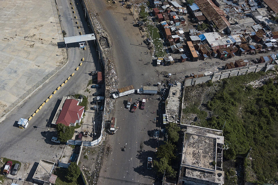 With trucks, gangs block access to the fuel terminals of Varreux in Port-au-Prince, Haiti, Sunday, Oct. 24, 2021. The ongoing fuel shortage has worsened, with demonstrators protesting for days in Haiti's capital to decry the severe shortage and a spike in insecurity. (AP Photo/Matias Delacroix)