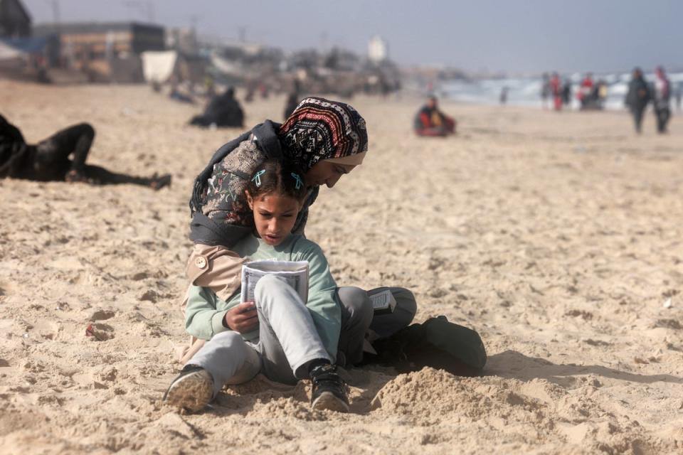 A Palestinian woman and a girl on a beach near a makeshift camp for displaced people in Rafah, southern Gaza, on Saturday (AFP via Getty)