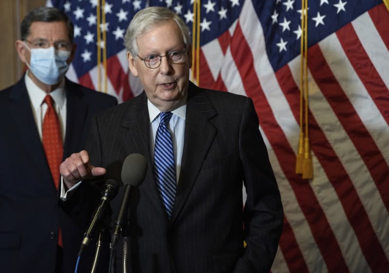 FILE - In this Tuesday, Dec. 15, 2020, file photo, Senate Majority Leader Mitch McConnell, of Kentucky, speaks during a news conference with other Senate Republicans on Capitol Hill in Washington, while Sen. John Barrasso, R-Wyoming, listens at left. "There will be another major rescue package for the American people," McConnell said in announcing an agreement for a relief bill, Sunday, Dec. 20, 2020, that would total almost $900 billion. "It is packed with targeted policies to help struggling Americans who have already waited too long." (Nicholas Kamm/Pool Photo via AP, File)