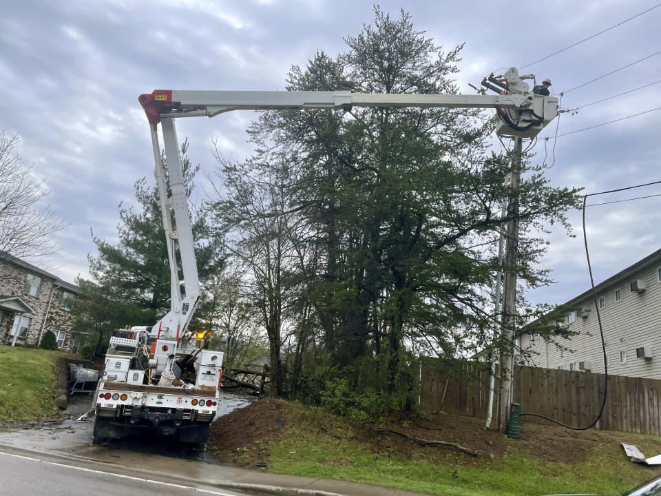 Utility crews work on a power line Tuesday, April 2, 2024, following severe storms in Cross Lanes, W.Va. (AP Photo/John Raby)