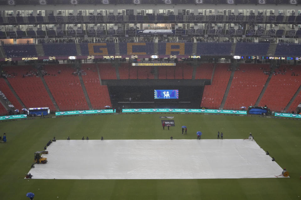 The pitch is covered due to bad weather and light rain before the start of Indian Premier League cricket match between Gujarat Titans and Kolkata Knight Riders at Narendra Modi stadium in Ahmedabad, India, Monday, May 13, 2024. (AP Photo/Ajit Solanki)