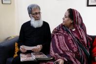 Ali Hasan Baqai, whose family was divided by the partition of the subcontinent in 1947, speaks with his wife as they go through the family picture album, at home in Karachi,