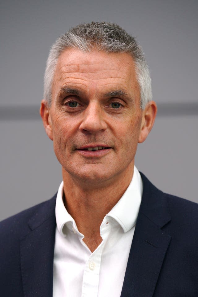 Head shot of Tim Davie in a white collared shirt and a black suit jacket