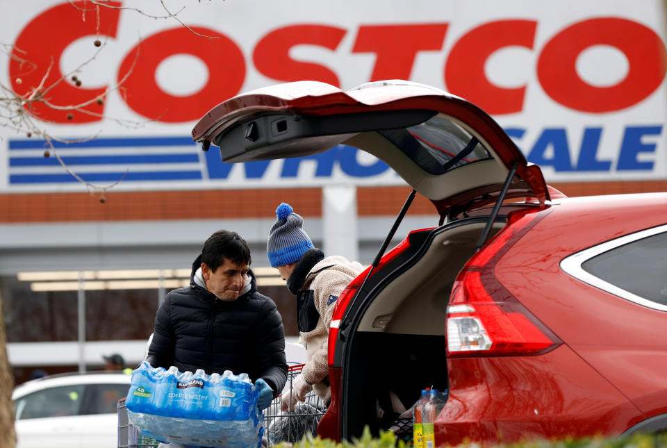 Shoppers load their car with bottled water at a Costco Wholesalers in Chingford, Britain March 15, 2020. REUTERS/John Sibley